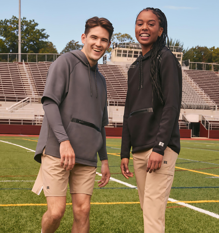 Male model wearing grey short sleeve tech fleece and khaki shorts.  Female model wearing long sleeve black legend fleece top and khaki legend pants.